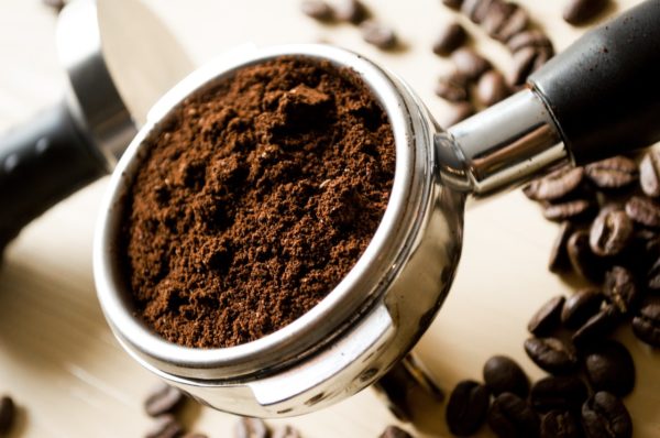 Freshly ground coffee on a coffee measuring scoop